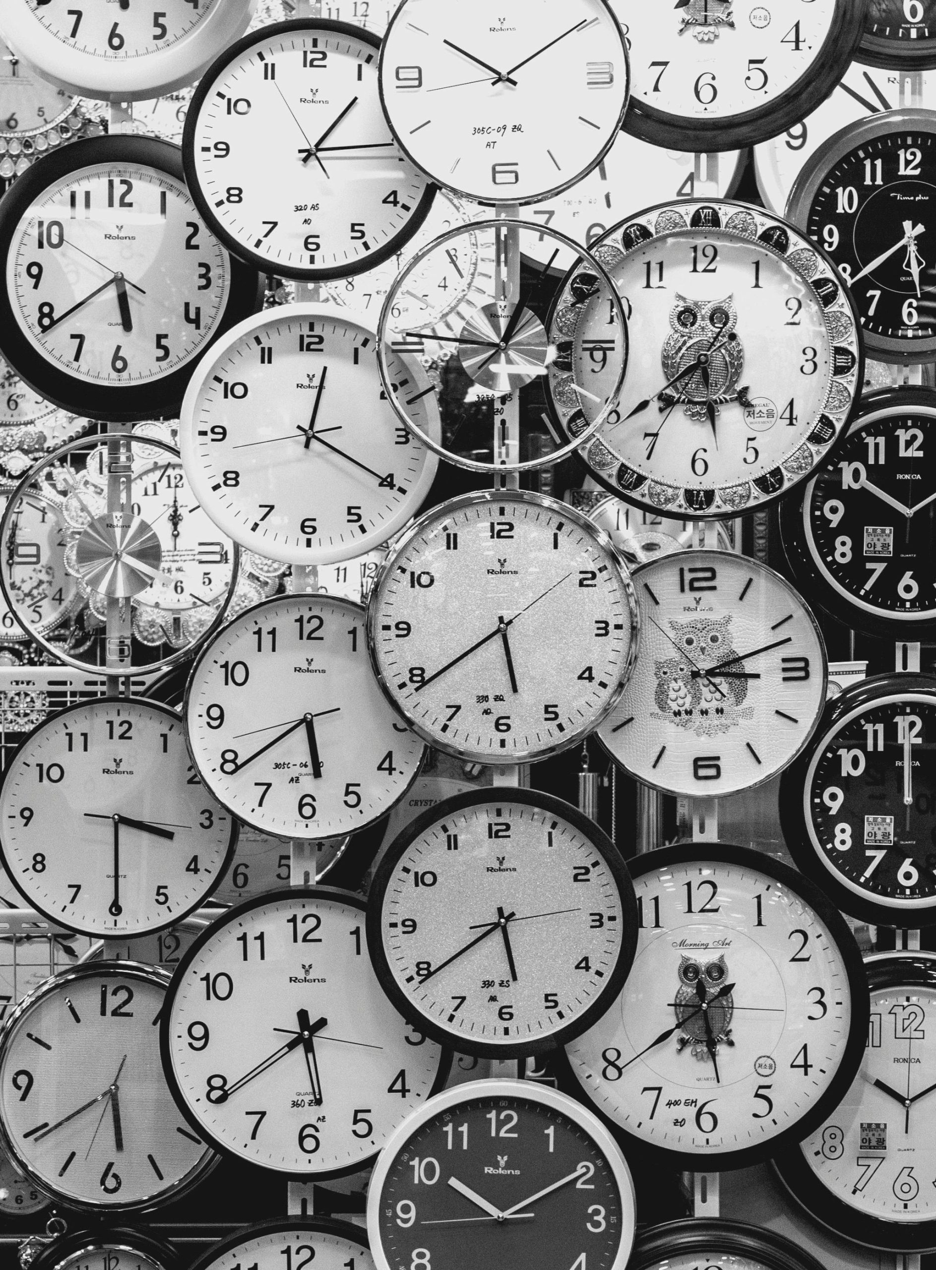 Une image en noir et blanc présentant une variété d'horloges murales vintage.