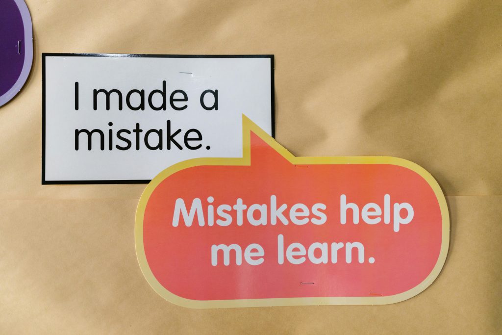 Bright square and speech bubble sign with motivational quotes about mistakes and learning. Panneau carré lumineux avec une bulle de dialogue contenant des citations motivantes sur les erreurs et l'apprentissage.