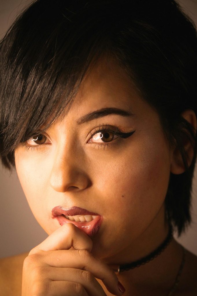 Close-up d'une jeune femme avec une expression pensive, mettant en valeur ses traits.