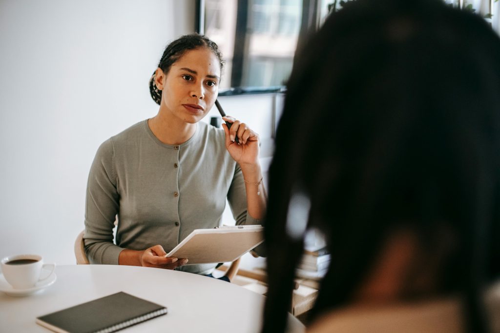Thérapeute discutant avec un client dans un cadre de bureau moderne. Concentration sur le soutien en santé mentale.