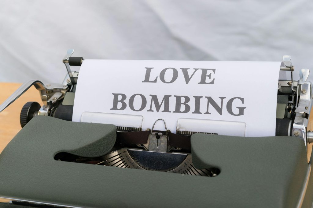 Close-up d'une machine à écrire affichant la phrase « Love Bombing » sur du papier.