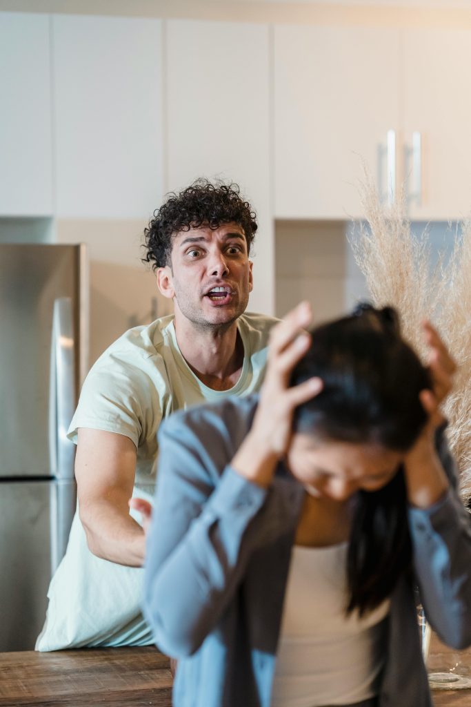 Un homme et une femme en confrontation émotionnelle tendue dans une cuisine.