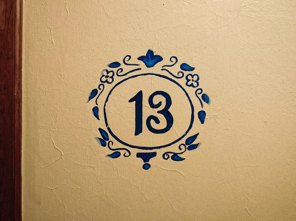 Artistique numéro 13 peint sur un mur texturé avec un motif floral bleu, Naolinco, Mexique