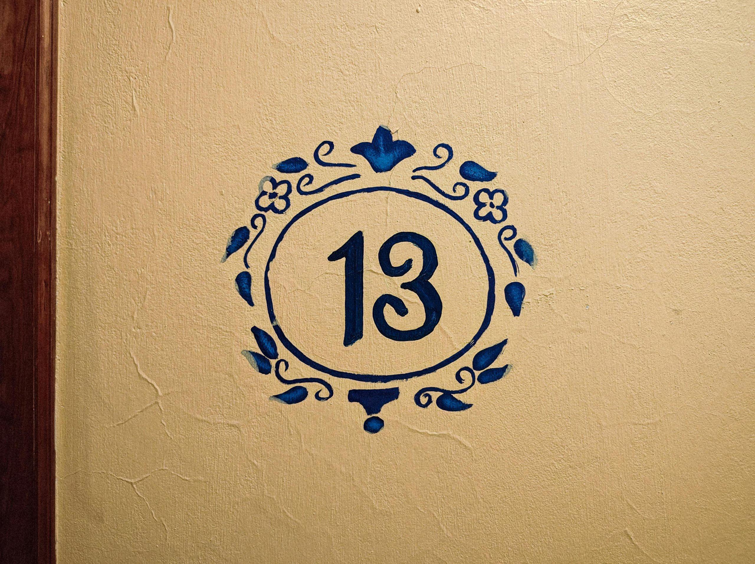 Artistique numéro 13 peint sur un mur texturé avec un motif floral bleu, Naolinco, Mexique