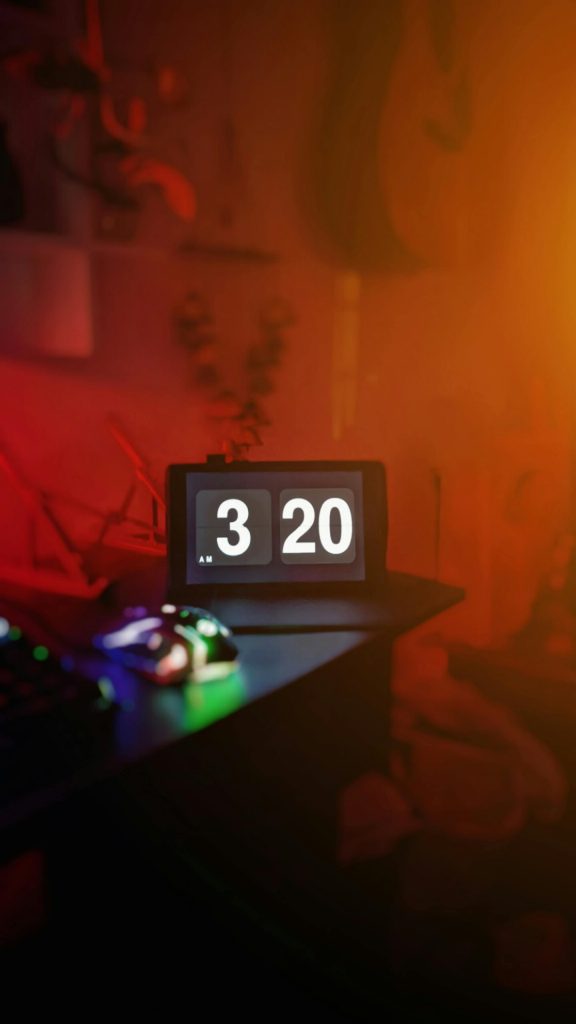 Gros plan d'une horloge numérique illuminée à l'intérieur avec une lueur ambiante colorée.