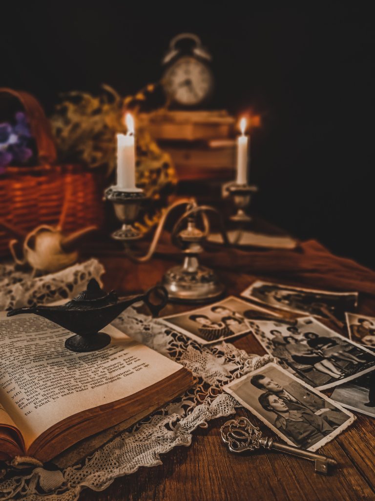A nostalgic scene with candles, an open book, and old photographs. Une scène nostalgique avec des bougies, un livre ouvert et de vieilles photographies.
