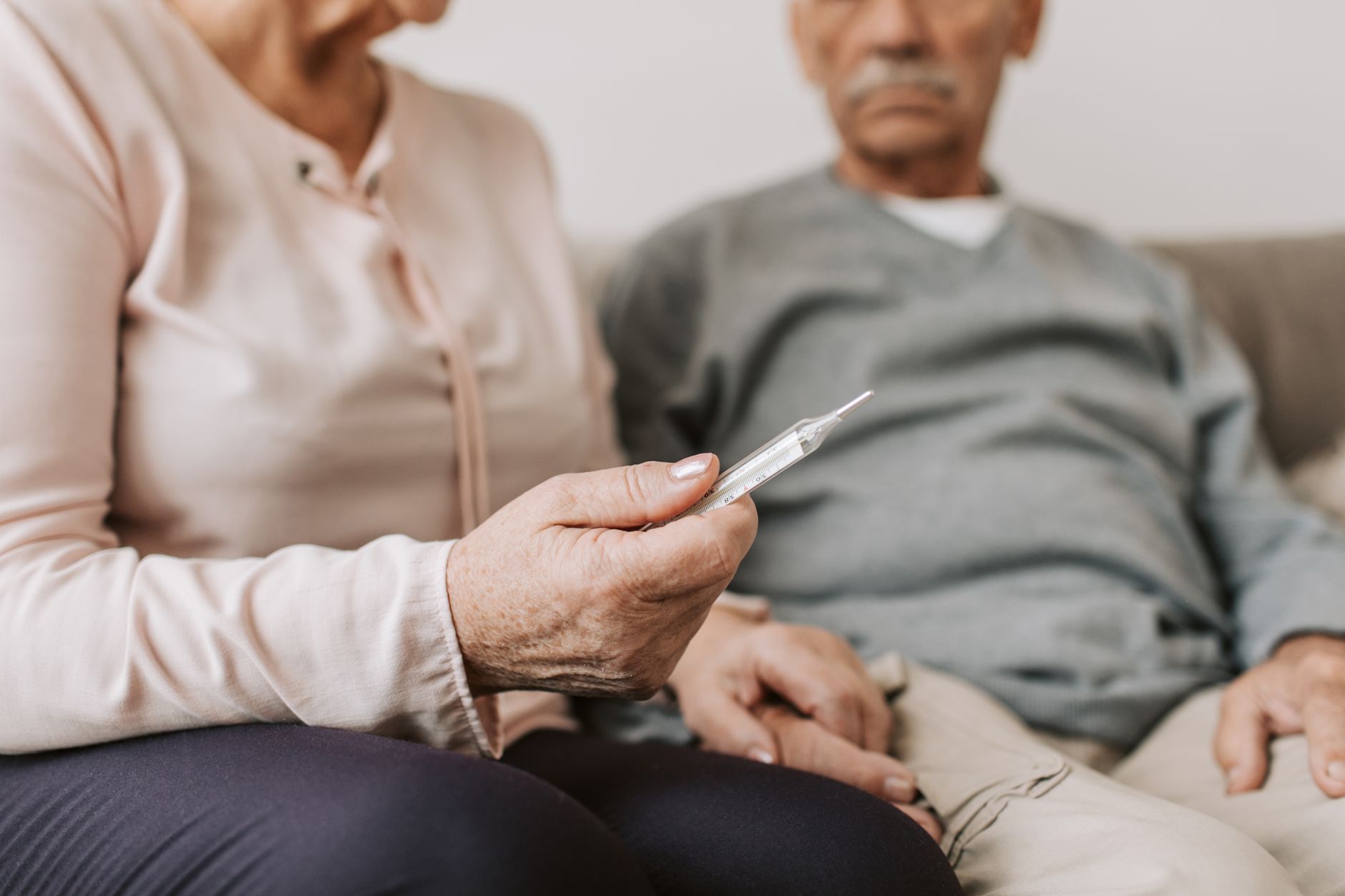 Couple âgé prenant une température ensemble à la maison