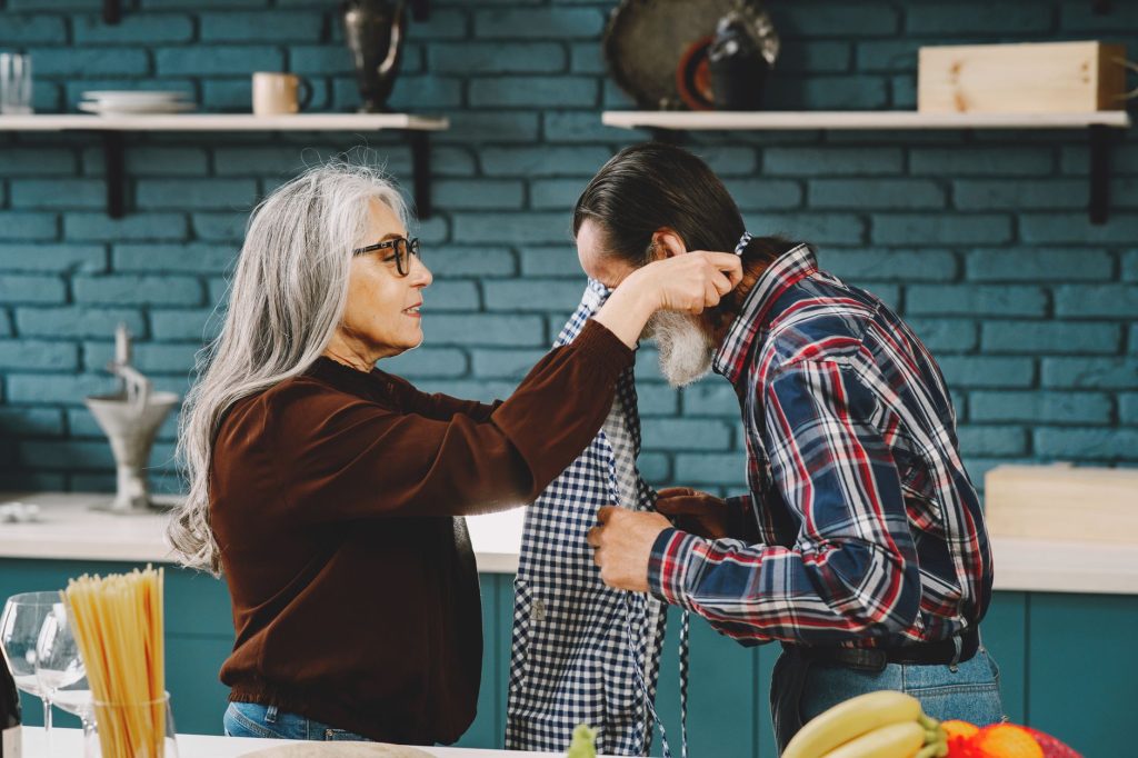 Couple de seniors partageant un moment complice en cuisine