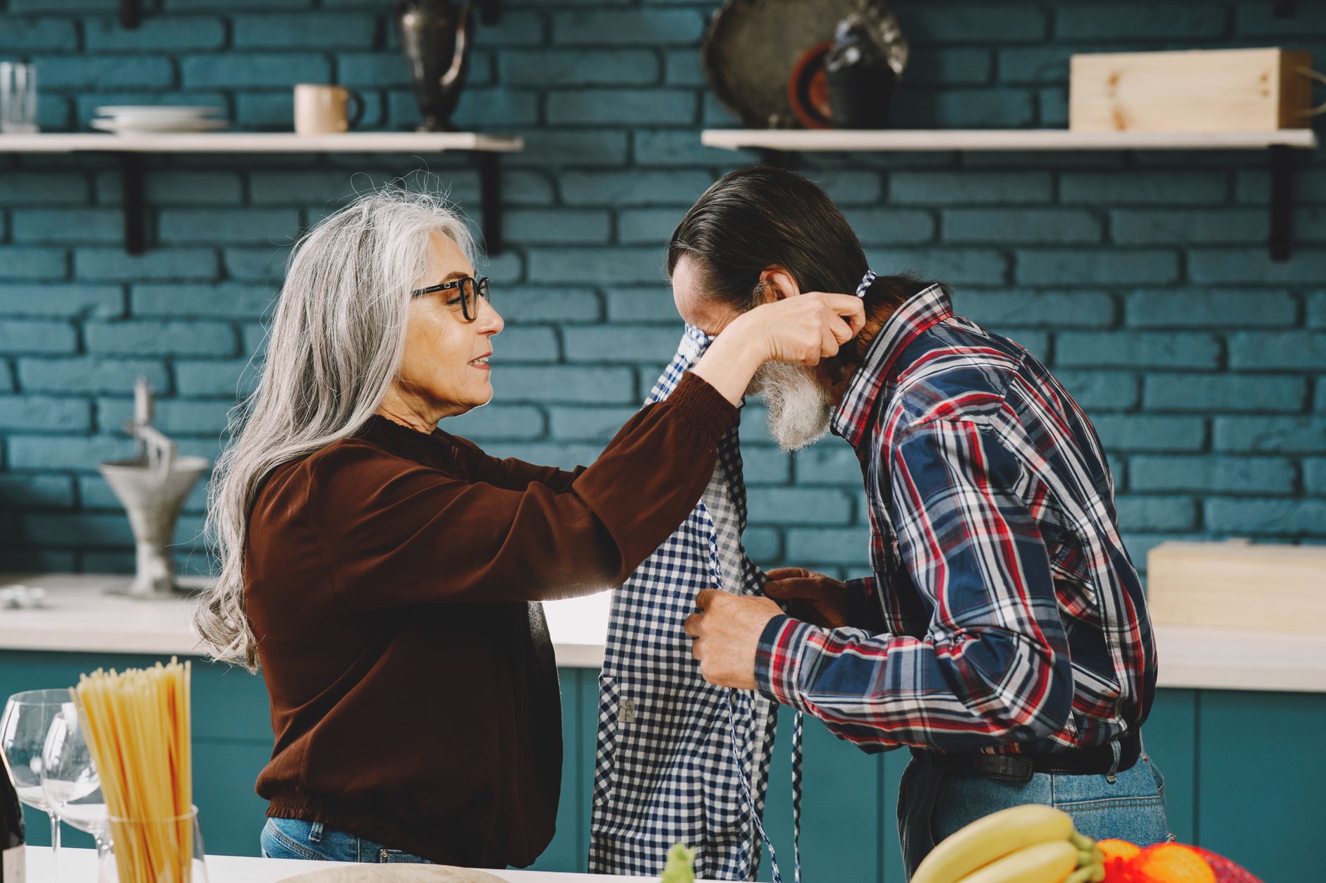 Couple de seniors partageant un moment complice en cuisine