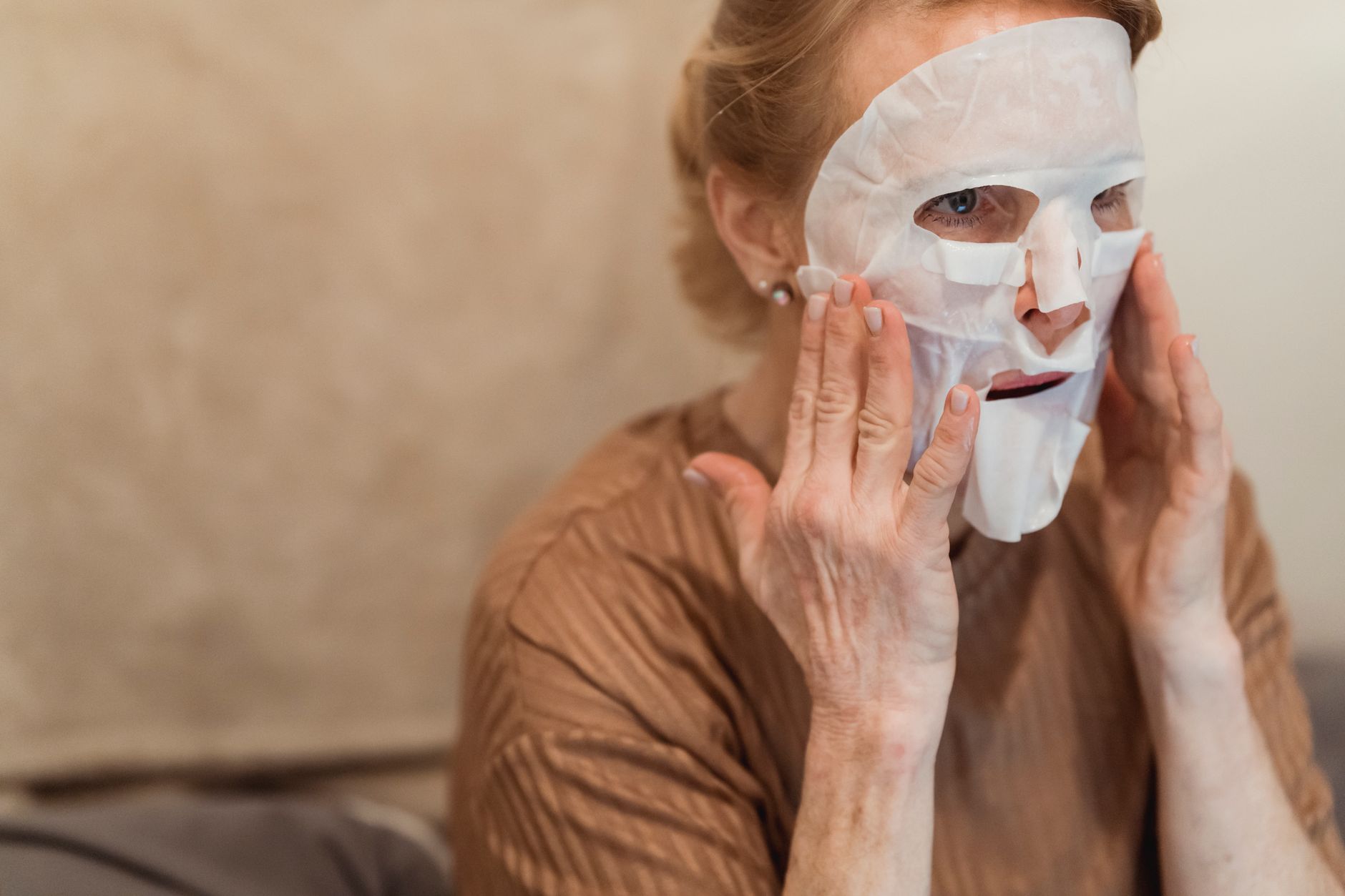 Femme senior appliquant un soin hydratant sur le visage