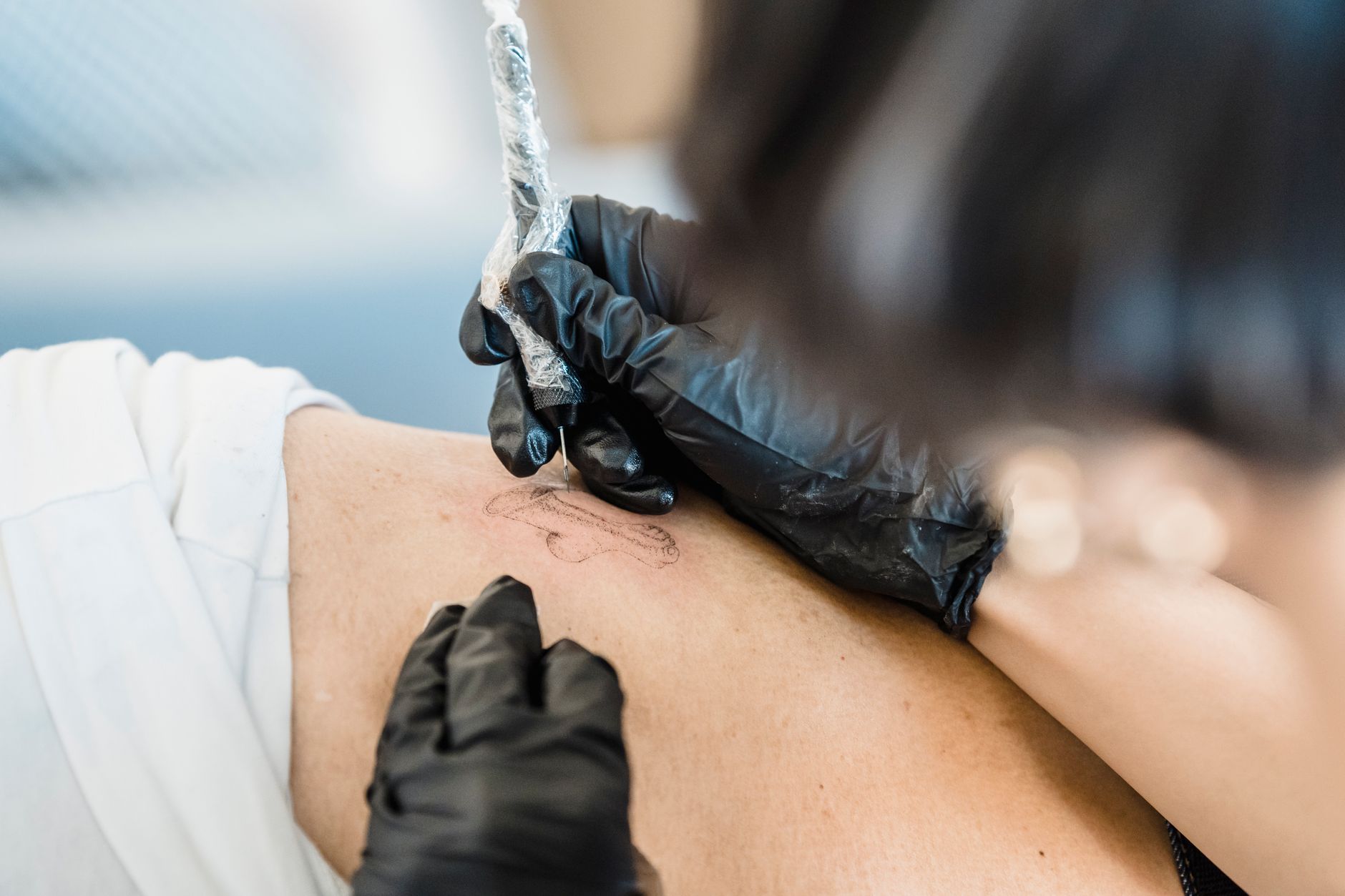 Tatoueur appliquant un tatouage sur la peau