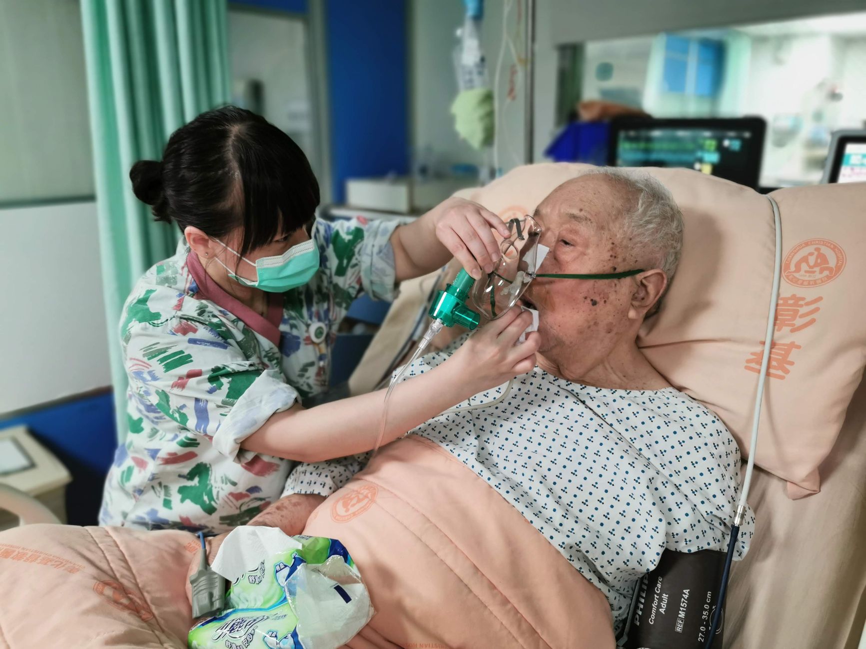Infirmière aidant un patient âgé sous oxygène