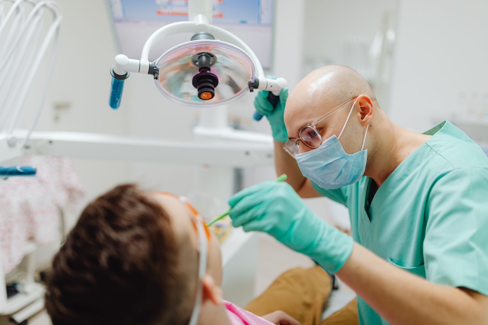 Dentiste en tenue verte soignant une patiente