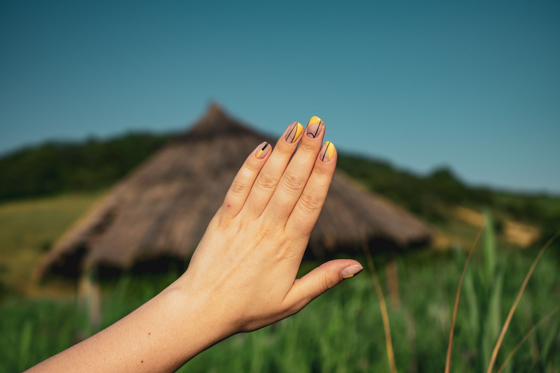 Main avec ongles décorés sur fond sobre