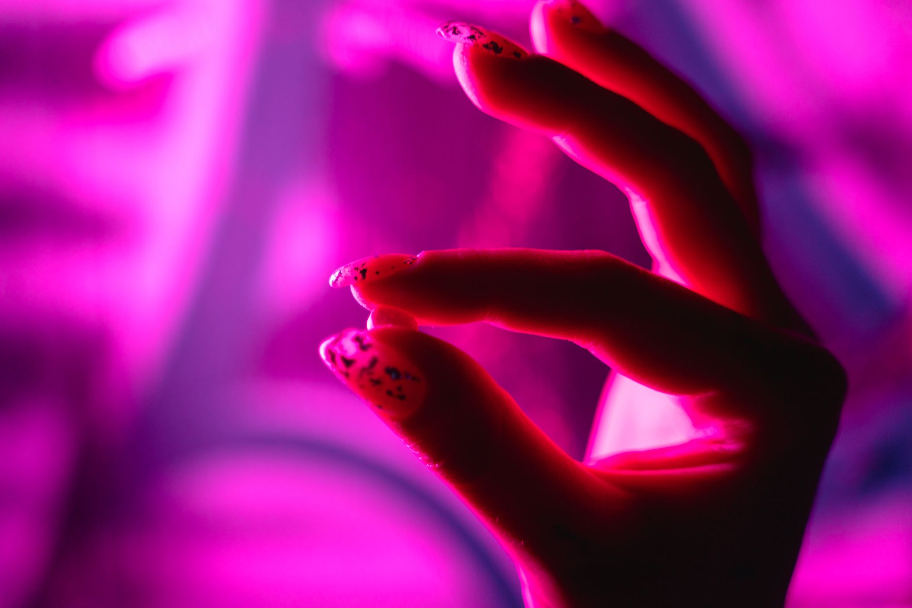 Mains avec nail art sous une lumière colorée