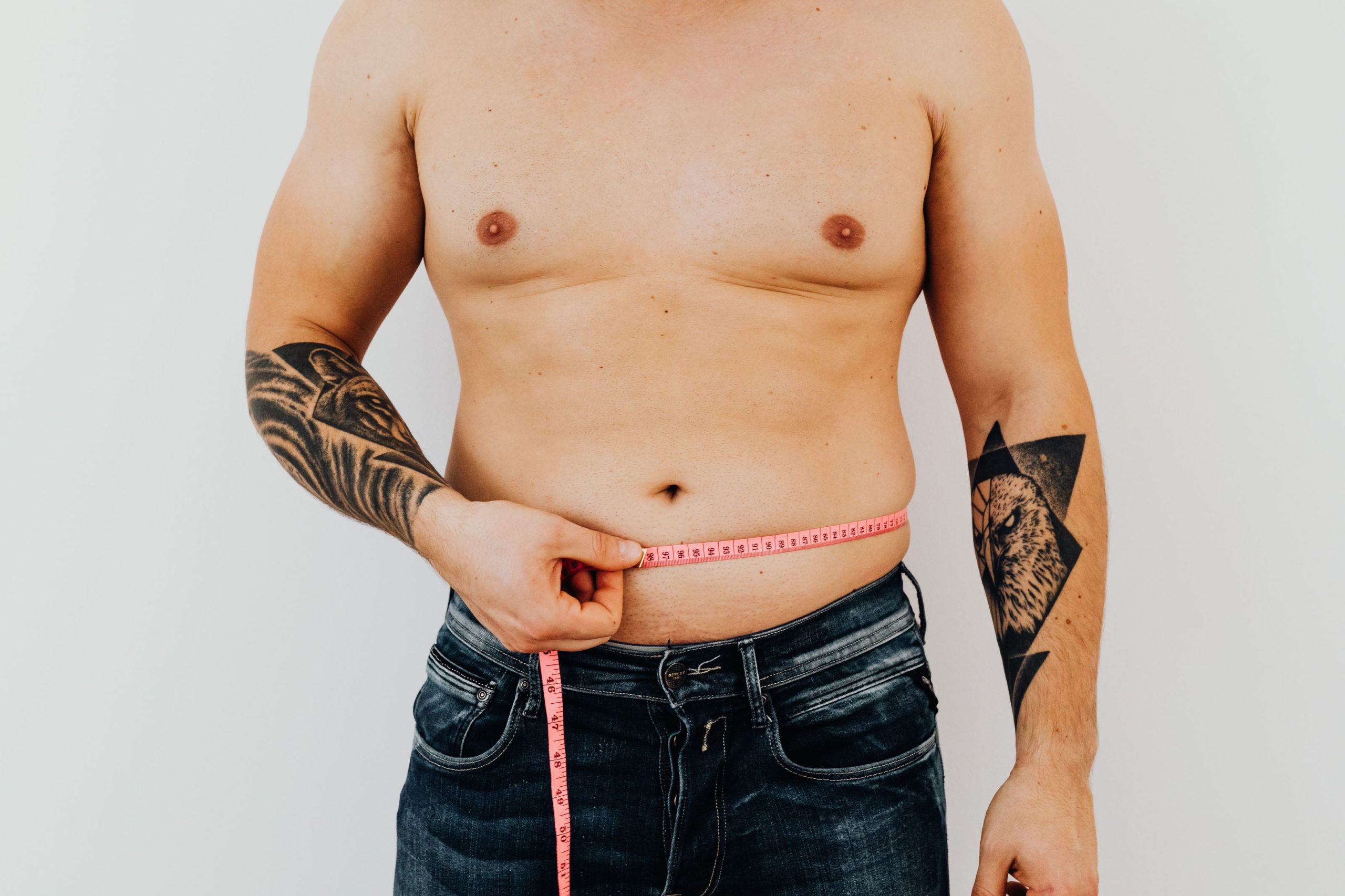 Homme qui mesure son tour de taille au mètre ruban